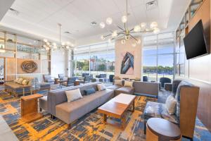ein Wohnzimmer mit Sofas, Tischen und Fenstern in der Unterkunft Hilton Garden Inn Fremont Milpitas in Fremont