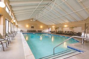 a large swimming pool with chairs in a building at DoubleTree by Hilton Hotel Grand Rapids Airport in Grand Rapids