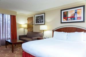 大急流城DoubleTree by Hilton Hotel Grand Rapids Airport的配有一张大床和一把椅子的酒店房间