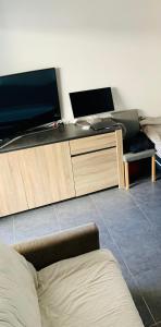 ein Wohnzimmer mit einem großen TV und einem Sofa in der Unterkunft Large studio with private parking Vallauris in Vallauris