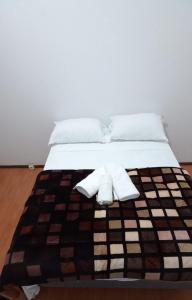 1 cama con 2 almohadas y toallas en Pousada A Cabana en Uruguaiana