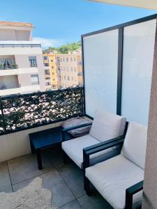 2 Stühle und ein Couchtisch auf dem Balkon in der Unterkunft Large studio with private parking Vallauris in Vallauris