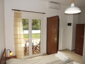 a bedroom with a sliding glass door to a balcony at Istira in Possidi