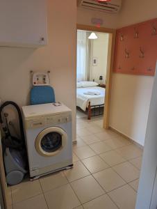 Habitación con lavadora y dormitorio en ALMA central apartment, en La Canea