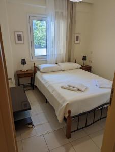1 dormitorio con 1 cama grande y 2 toallas. en ALMA central apartment, en La Canea