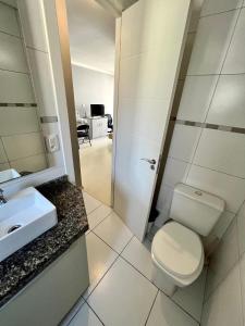 a bathroom with a toilet and a sink and a mirror at Pasqualetto in Caxias do Sul