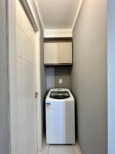 a washer and dryer in a small room with a door at Pasqualetto in Caxias do Sul