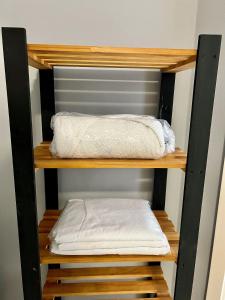 - une étagère en bois avec 2 serviettes blanches dans l'établissement Pasqualetto, à Caxias do Sul
