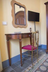 escritorio de madera con espejo y silla en Altevolte Rooms, en Catania