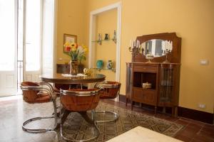 Habitación con mesa, sillas y espejo. en Altevolte Rooms, en Catania