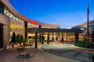 un edificio iluminado con mesas y sillas delante de él en Hilton Washington Dulles Airport, en Herndon