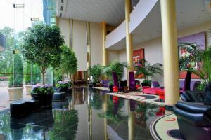 a lobby with chairs and plants in a building at Hilton Washington Dulles Airport in Herndon