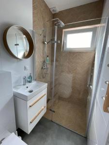 a bathroom with a shower and a sink and a mirror at Apartamenty A1 in Gdynia