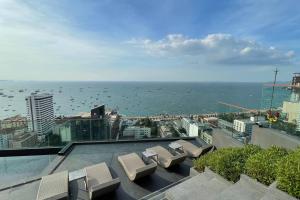 a view of the ocean from a building with chairs at Edge Seaside Luxury Stylish Condo steps away from beach in Pattaya Central