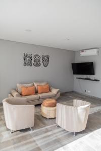 een woonkamer met een bank en 2 stoelen bij Liniers Green Apartments in Chacras de Coria