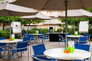 een groep tafels en stoelen met parasols bij DoubleTree Suites by Hilton Phoenix in Phoenix