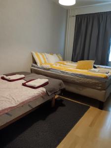 two twin beds in a room with a window at City apartment Pikkuvuori in Turku