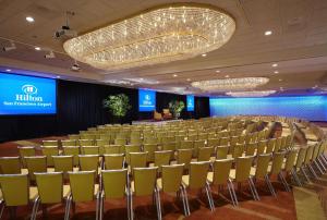 une salle de conférence avec des chaises et une scène dans l'établissement Hilton San Francisco Airport Bayfront - No Resort Fee, à Burlingame