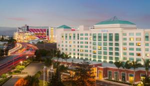 a large white building with a green roof on a city street at Hilton Santa Clara in Santa Clara