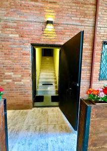 um corredor com uma parede de tijolos e um elevador preto em Vato Home em Tbilisi