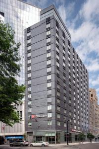 un grande edificio grigio con macchine parcheggiate di fronte di Hilton Garden Inn Long Island City a Queens