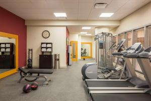 a gym with treadmills and cardio equipment and a clock at Hilton Garden Inn Long Island City in Queens