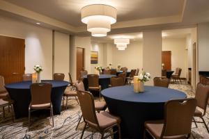 皇后區的住宿－Hilton Garden Inn Long Island City，一间会议室,配有两张桌子和椅子,还有一组