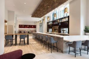 a bar in a restaurant with chairs and tables at Hilton Garden Inn Long Island City in Queens