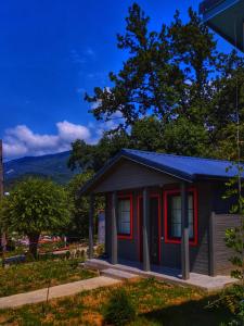 ein kleines Haus mit roter Ausstattung im Hof in der Unterkunft Brotseulebi in Ambrolauri