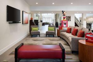 a lobby with a couch and chairs and a tv at Homewood Suites by Hilton-Anaheim in Anaheim