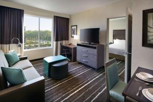 Habitación de hotel con cama, escritorio y TV. en Homewood Suites by Hilton Aliso Viejo Laguna Beach en Aliso Viejo