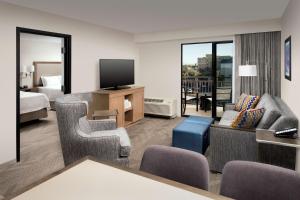 una camera d'albergo con divano, TV e letto di Hampton Inn & Suites Anaheim Garden Grove ad Anaheim