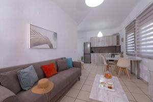 a living room with a couch and a kitchen at Calliroè Aesthetic Centro Apt in Heraklio