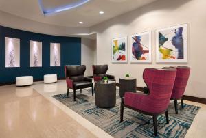 una sala de espera con sillas y pinturas en la pared en Hilton Garden Inn Denver/Cherry Creek, en Denver