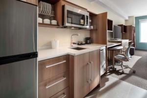 a kitchen with a sink and a refrigerator at Home2 Suites By Hilton Denver Downtown Convention Center in Denver