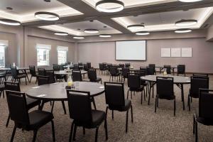 丹佛Home2 Suites By Hilton Denver Downtown Convention Center的配有桌椅和屏幕的会议室