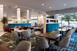 um restaurante com mesas e cadeiras num quarto em Hilton Garden Inn Denver/Cherry Creek em Denver