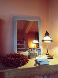 a mirror on a desk with a lamp and books at B&B Roos 14 in Waanrode