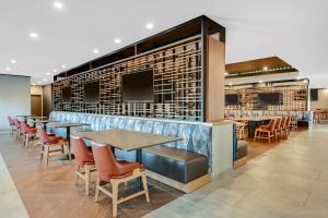 um restaurante com mesas e cadeiras e um bar em DoubleTree by Hilton Denver International Airport, CO em Denver