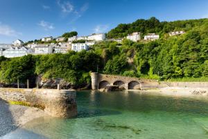 a bridge over a river with houses on a hill at The Decker Apartment in Looe