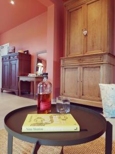 a bottle of whiskey and a book on a table at B&B Roos 14 in Waanrode