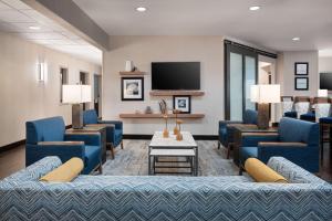 a waiting room with blue couches and a tv at Hampton Inn Boulder/Louisville in Louisville