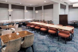 une grande salle avec des tables et des chaises dans un restaurant dans l'établissement Hilton Garden Inn Frisco, à Frisco