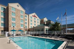 a hotel with a swimming pool in front of a building at Hilton Garden Inn Frisco in Frisco