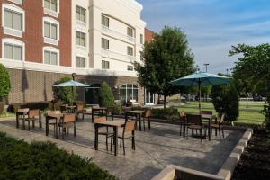 a patio with tables and chairs and umbrellas in front of a building at Hilton Garden Inn DFW North Grapevine in Grapevine