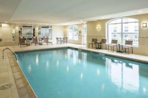 格雷普韋恩的住宿－沃思堡機場北格雷普韋恩希爾頓花園旅館，酒店的大型游泳池配有桌椅