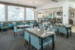 Hilton Garden Inn DFW North Grapevine في جريبفاين: غرفة طعام مع طاولات وكراسي زرقاء