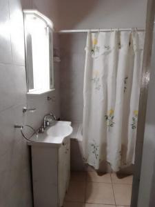 a bathroom with a sink and a shower curtain at Complejo Kalifornia in Pilar