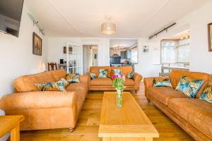 a living room with couches and a table at The Decker Apartment in Looe
