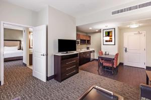 a hotel room with a bed and a desk with a television at Homewood Suites Dallas Downtown in Dallas